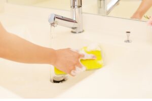洗面台を掃除する女性の手
