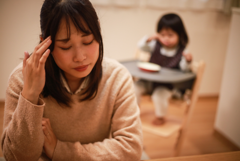 頭を抱えて悩む女性