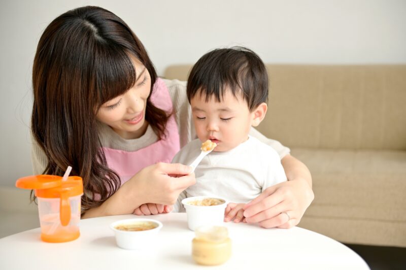 離乳食を食べさせている母親