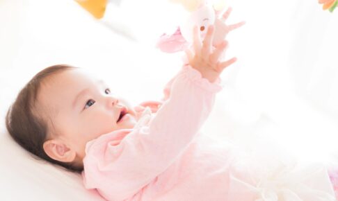 仰向け姿勢で遊ぶ赤ちゃん